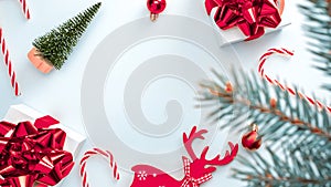 Christmas background. White gifts with scarlet bow, red balls and sparkling lights in xmas decoration on white background for