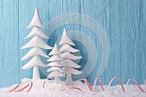 Christmas background with white Christmas trees and snow, blue wooden background photo