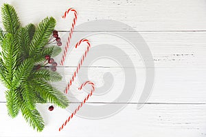 Christmas background wood composition fir branches pine and red berries / christmas decoration pine tree candy cane festive xmas