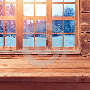Christmas background with wooden empty table over window and winter nature landscape. Winter holiday house interior