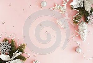 Christmas background. Xmas or new year white silver color decorations on pastel pink background with empty copy space for text.