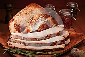 Christmas baked ham chopped slices on wooden board with spices.