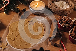 Christmas bakery of gingerbread, cutting cookies of gingerbread dough. Christmas and New Year traditions concept. Candle