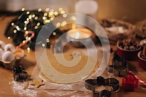 Christmas bakery of gingerbread, cutting cookies of gingerbread dough. Christmas and New Year traditions concept. Candle