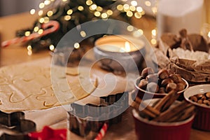 Christmas bakery of gingerbread, cutting cookies of gingerbread dough. Christmas and New Year traditions concept. Candle