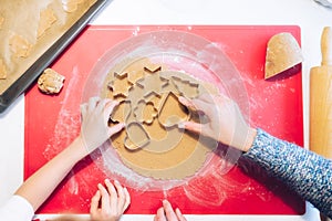 Christmas bakery. Mother and child making gingerbread,cutting cookies of gingerbread dough, view from above