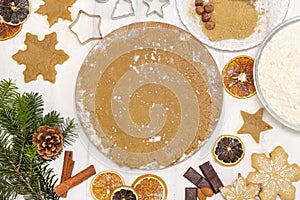 Christmas baking background with copy space for a greeting text, peace of dough rolled out for cooking Xmas gingerbreads,