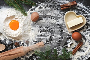 Christmas baking background, flour, butter, eggs decorated with spruce twigs. Top view, copy space