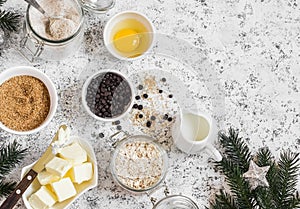 Christmas baking background. Flour, sugar, butter, rolled oats, eggs, chocolate chips on a light background.