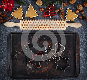 Christmas baking concept. Cookie cutters, gingebread cookies, rolling pin,  gift box, cinnamon and holiday decoration