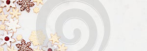 Christmas baking corner border with a variety of snowflake cookies on a white marble banner background