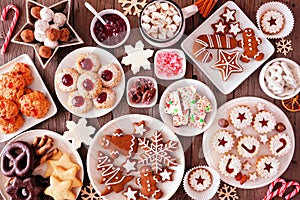 Christmas baking table scene with assorted sweets and cookies, top view over a rustic wood background