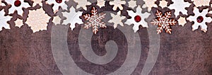 Christmas baking top border of snowflake cookies on a dark stone banner background