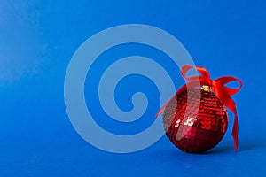 Christmas ball on colored background. decoration bauble with ribbon bow with copy space