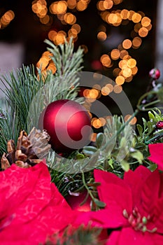 Christmas ball with fir branches and light bokeh in the background