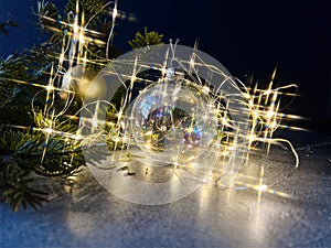 Christmas ball, fir tree branch and string lights with star burst  effect