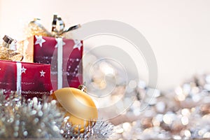 Christmas ball and gifts on light background