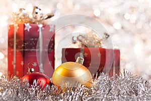 Christmas ball and gifts on light background