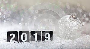 Christmas ball and new year 2019, on snow, abstract bokeh lights background