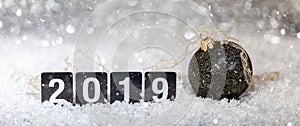 Christmas ball and new year 2019, on snow, abstract bokeh lights background