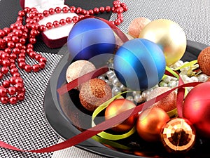 Christmas ball and pearls on a plate, new year holiday