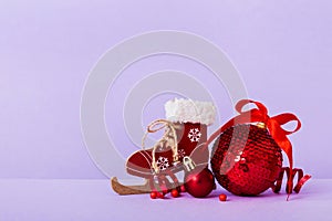 Christmas ball with skates on colored background. decoration bauble with ribbon bow with copy space