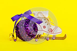 Christmas ball with skates on colored background. decoration bauble with ribbon bow with copy space