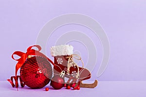 Christmas ball with skates on colored background. decoration bauble with ribbon bow with copy space