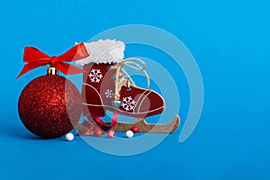 Christmas ball with skates on colored background. decoration bauble with ribbon bow with copy space