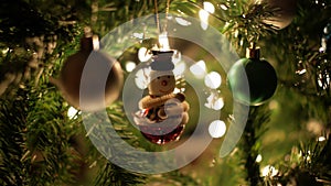 Christmas ball, snowman garland decoration on Christmas tree with bokeh lights