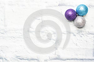 Christmas balls decorations in silver and blue on a light brick background. Copy space. Flat lay