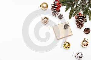 Christmas balls, gift box with fir tree and conifer cone on wood background, top view. Copy space