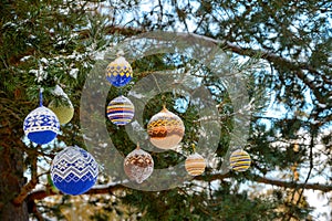 Christmas balls hanging on pine branches covered with snow