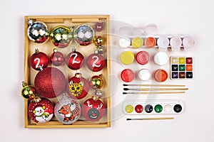 Christmas balls painted with gouache. Children kids DIY painting hand-made concept. Making christmas tree decoration.