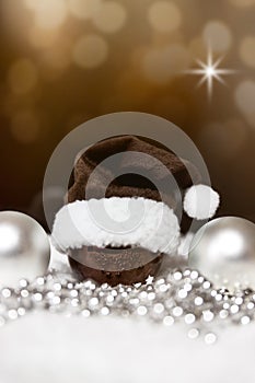 christmas balls, pointed hat and pearls, festive brown background with stars