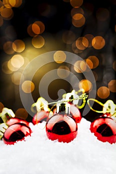 Christmas balls in the snow with golden bokeh