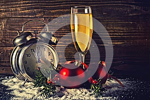 Christmas balls and vintage clock with glass of champagne