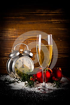 Christmas balls and vintage clock with glass of champagne