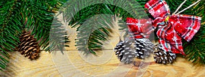 Christmas banner with fir tree branch, pine cones and decorations on wooden background