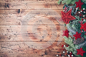 Christmas banner with fir tree branches and red stars decorations on wooden background