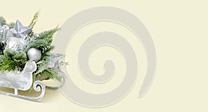 Christmas banner with fir tree branches and silver winter decorations in a rustic sleigh