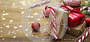 Christmas banner. Gift boxes wraped in craft paper over wooden background. Top view, rustic style. Copy space.