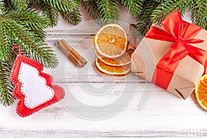 Christmas banner with green tree, giftbox, handmade felt decoration, orange and cinnamon on white wooden background