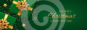 Christmas banner. Realistic green gift boxes with golden bow, gold stars and glitter confetti. Xmas background, horizontal