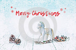 Christmas bauble horse and fir cones on white wooden background