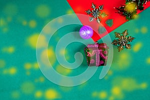 Christmas bauble,snow flake ,presents ,star and leaves on Red green background with snow fall,top  view with copy space