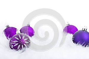 Christmas baubles on a feathery surface, brightly lit