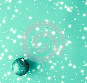 Christmas baubles on green background with snow glitter, luxury winter holiday card