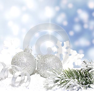 Christmas baubles and silver ribbon on snow