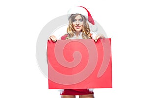 Christmas. Beautiful muscular sexual happy woman in Santa Claus clothes. Keeps blank whiteboard. Isolated on white